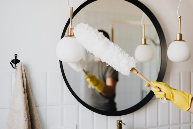 Person dusting a light shade